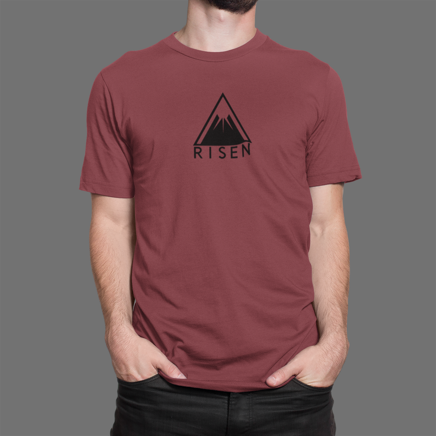 The Peak Men’s Christian T-Shirt featuring RISEN mountain graphic on maroon fabric, designed for elevation and purpose.