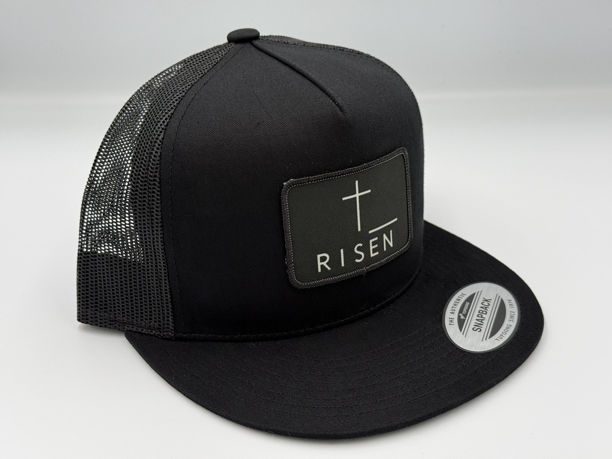 Black Canvas Patch Snapback – RISEN Structured Trucker Hat with a clean design and durable construction.