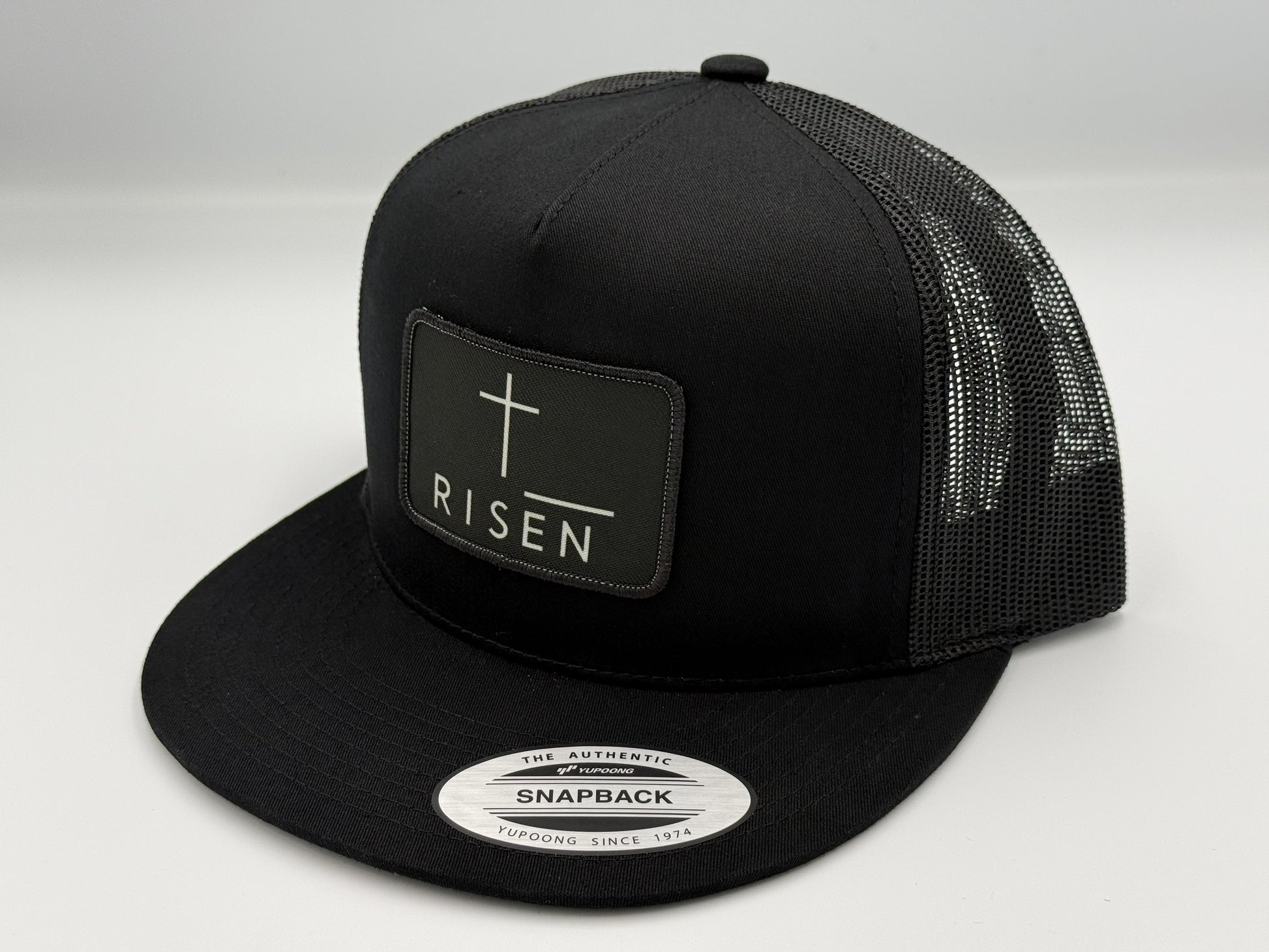 Black Canvas Patch Snapback – RISEN Structured Trucker Hat with high-profile crown and mesh back.